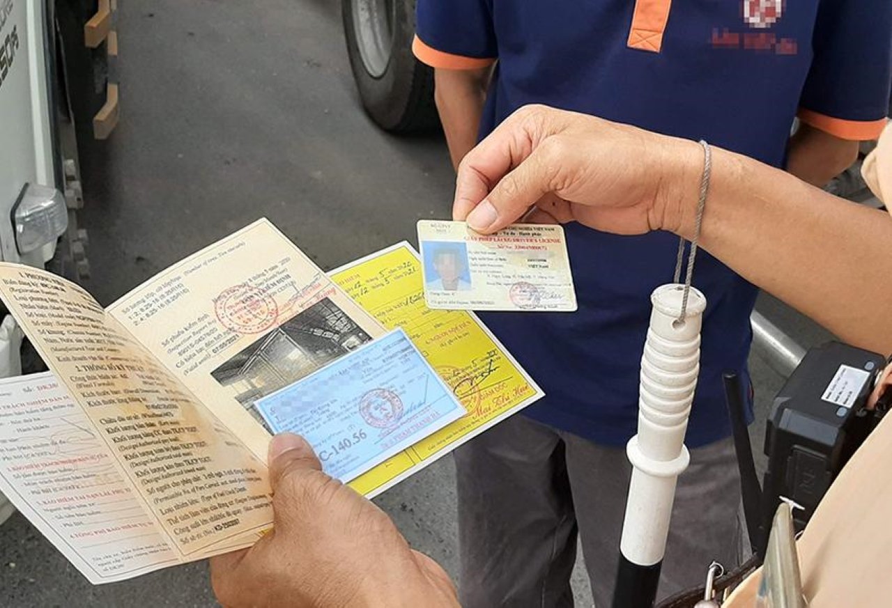 Lưu ý khi sử dụng bảo hiểm xe máy Người tham gia giao thông cầm giấy chứng nhận bảo hiểm