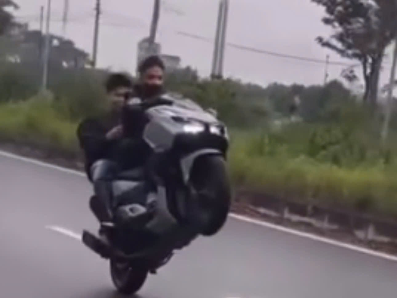 Hai thanh niên bốc đầu xe máy không đội mũ bảo hiểm